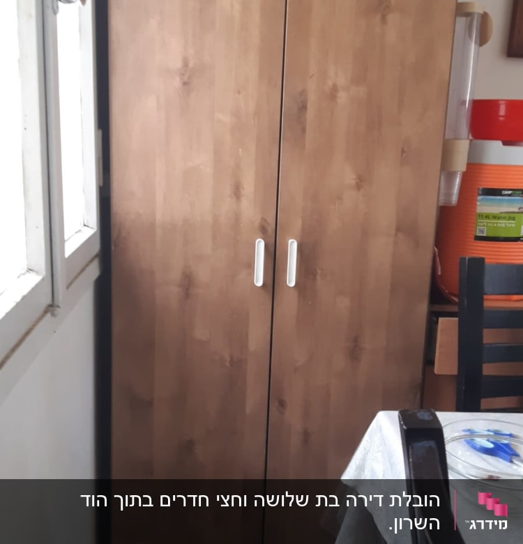 ארון עץ עם ידיות לבנות ליד פח שחור
